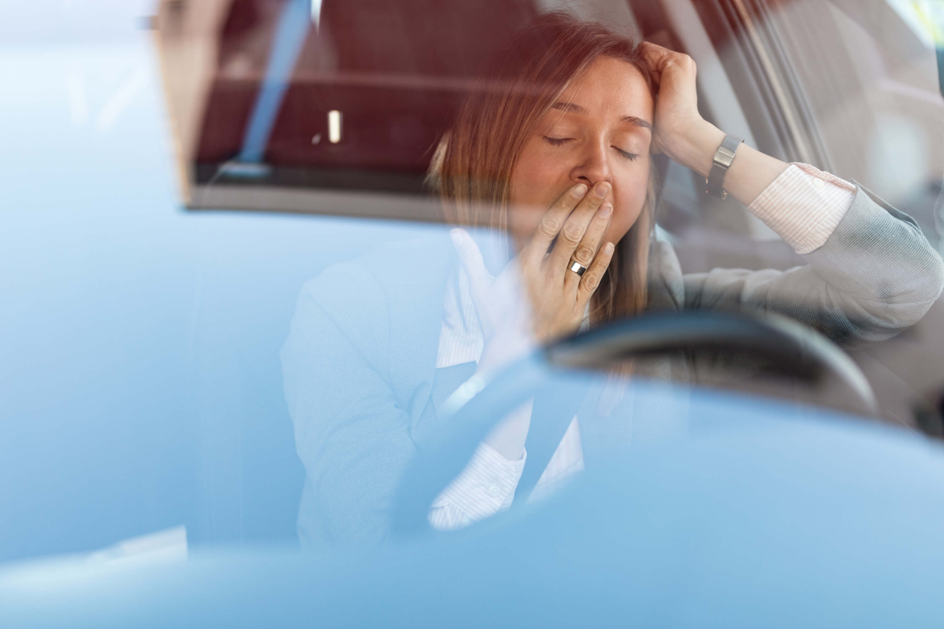 Een vermoeide vrouw in de auto